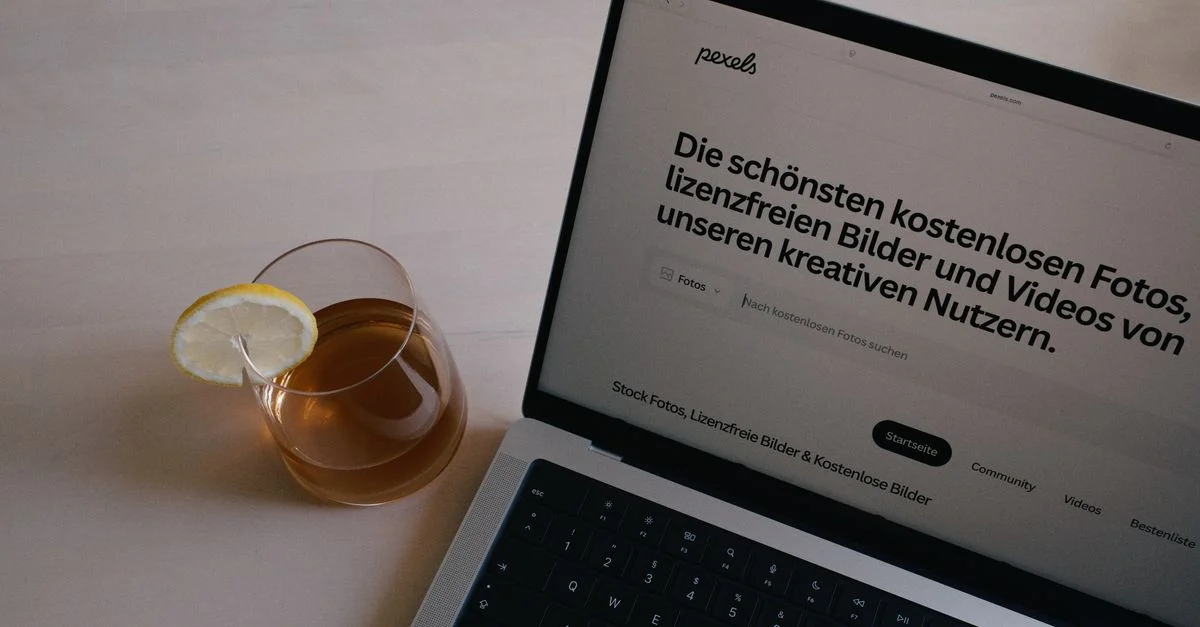 Un ordinateur portable sur un bureau à côté d'un verre de thé au citron, l'idéal pour travailler ou étudier.