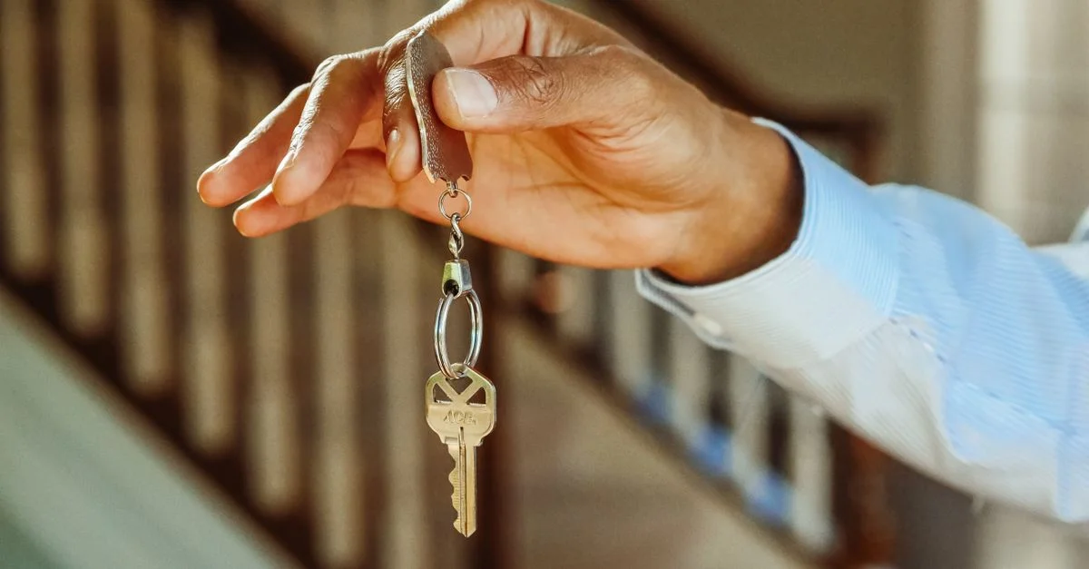 Un gros plan d'une main tenant une clé de maison, indiquant une nouvelle propriété ou location.