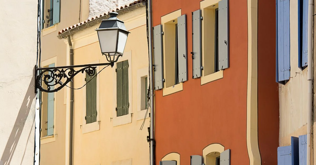 Maisons de ville colorées et lampadaire dans une étroite rue méditerranéenne.