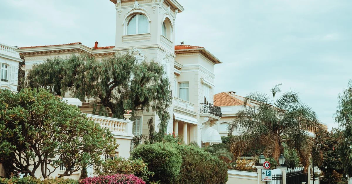 Une villa magnifique avec une architecture classique, entourée de verdure et d'un jardin vibrant.