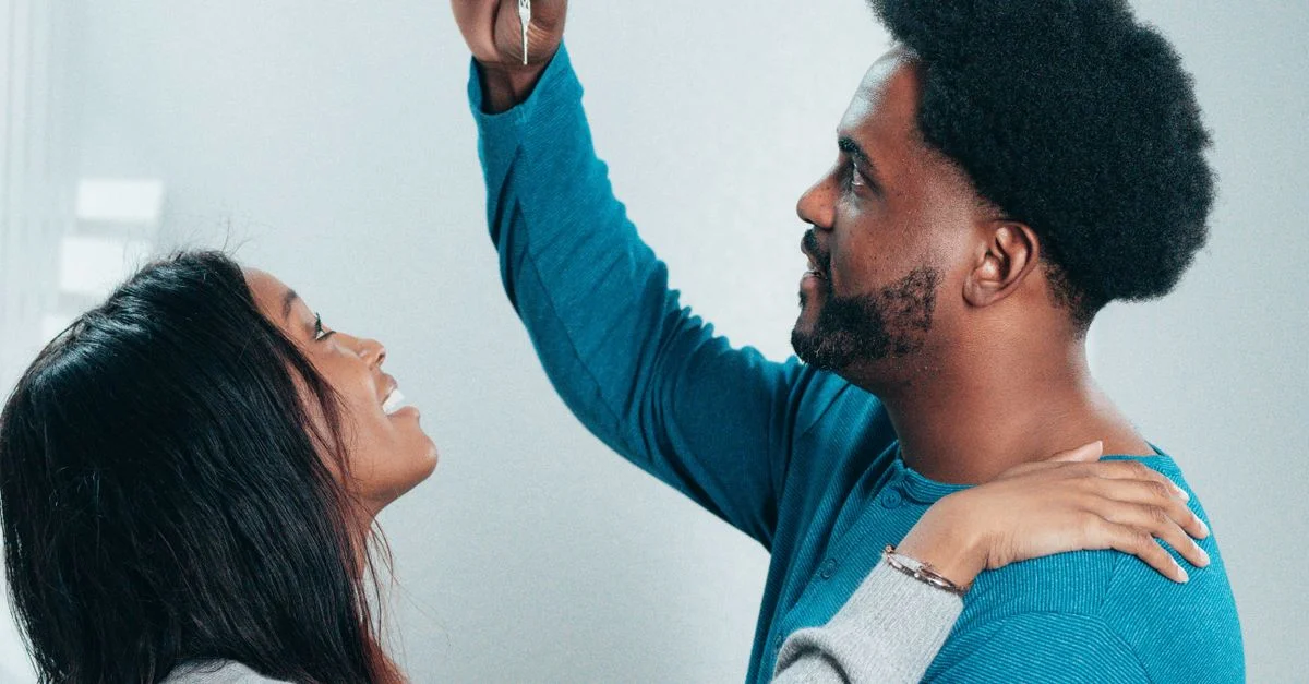 Un couple joyeux célèbre la réception de la clé de leur nouvelle maison, symbolisant de nouveaux départs.