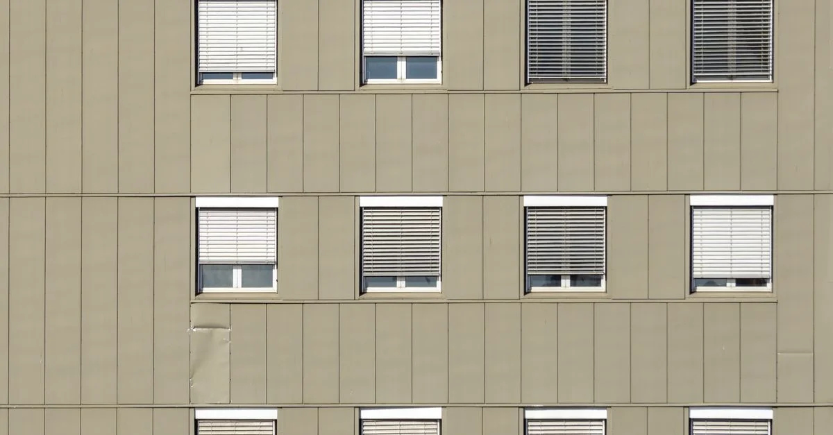 Façade d'appartement moderne à Oslo avec un design géométrique et des fenêtres uniformes.