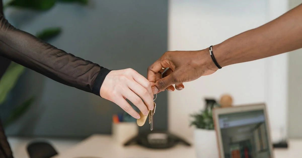 Un cadre de bureau professionnel montrant un échange de clés symbolisant un accord commercial ou une transaction immobilière.